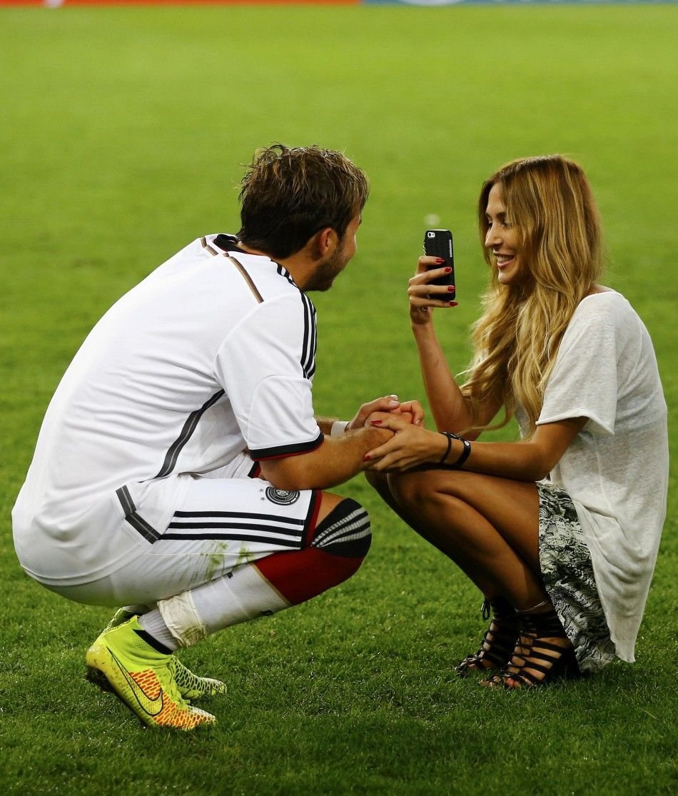Germanys Mario Goetze L has his picture taken by model girlfriend Ann-Kathrin Brommel after they won their 2014 World Cup final against Argentina at the Maracana stadium in Rio de Janeiro July 13, 2014.