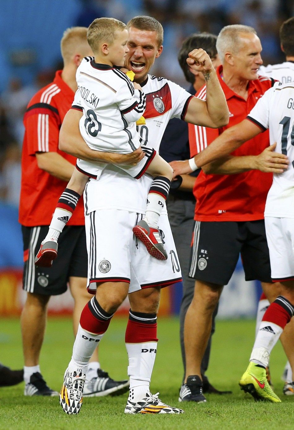 Germanys Lukas Podolski carries his child