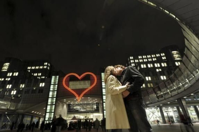 A couple kiss in front of a large neon heart that is lit above the entrance of Altiero Spinelli building of the European Parliament in Brussels December 17, 2012. A couple kiss in front of a large neon heart that is lit above the entrance of Altiero Spine