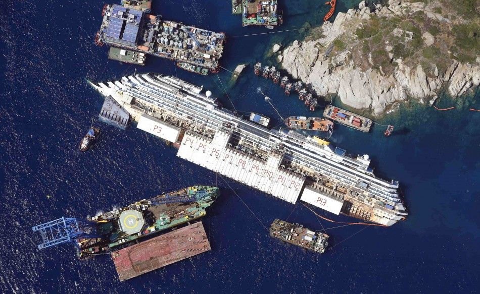 An aerial view shows the Costa Concordia as it lies on its side next to Giglio Island taken from an Italian navy helicopter in this August 26, 2013 file photo. The wreck of the Costa Concordia cruise liner is set to be refloated within 10 days, to be towe