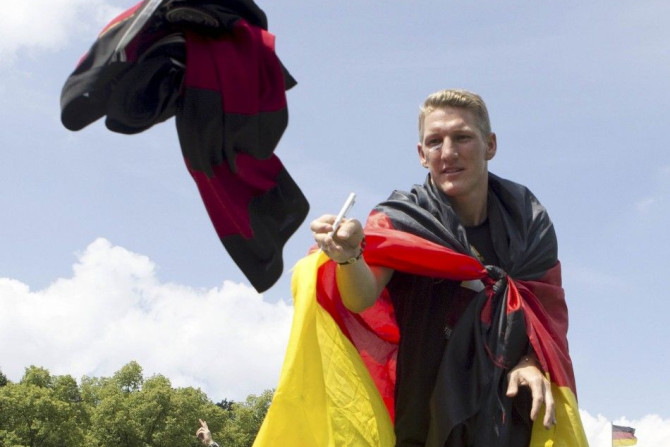 German soccer player Bastian Schweinsteiger catches a shirt to sign an autograph during celebrations to mark the team's 2014 Brazil World Cup victory