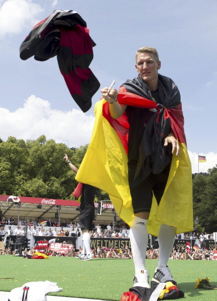 German soccer player Bastian Schweinsteiger catches a shirt to sign an autograph during celebrations to mark the team's 2014 Brazil World Cup victory