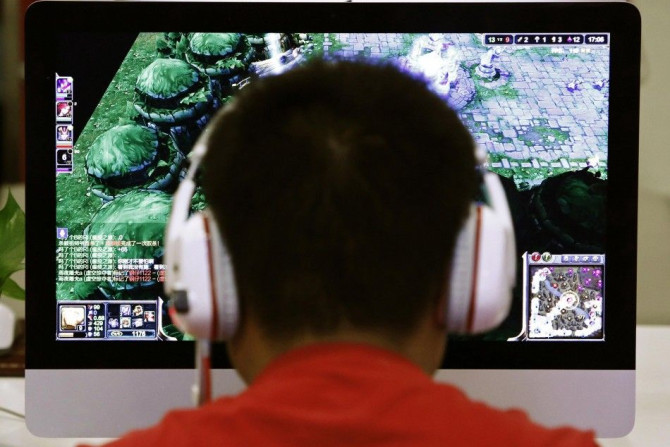 A man plays a computer game at an internet cafe