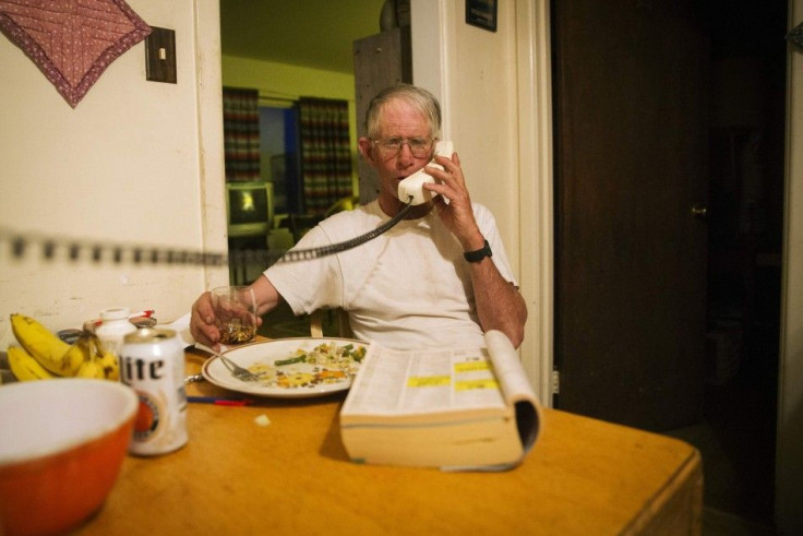 Cowboy David Thompson talks on the telephone while eating dinner at the end of the day during a week-long operation to gather cattle, near Ignacio, Colorado