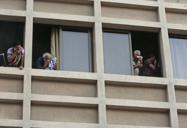 Guests staying in Duroy hotel cover their noses as they look out from windows