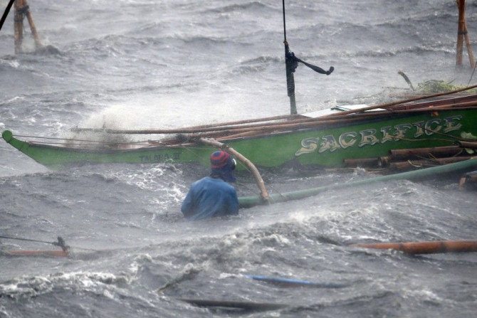 A fisherman secures his boat as Typhoon Rammasun (locally named Glenda) hits the coastal town of Imus, Cavite southwest of Manila, July 16, 2014. Philippine authorities evacuated almost 150,000 people from their homes and shuttered financial markets, gove