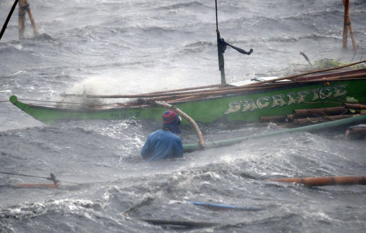 A fisherman secures his boat as Typhoon Rammasun (locally named Glenda) hits the coastal town of Imus, Cavite southwest of Manila, July 16, 2014. Philippine authorities evacuated almost 150,000 people from their homes and shuttered financial markets, gove