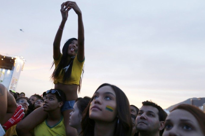 A Brazilian soccer fan takes a selfie as she watches the match between Brazil and Cameroon which was broadcast on a large screen at Copacabana beach in Rio de Janeiro