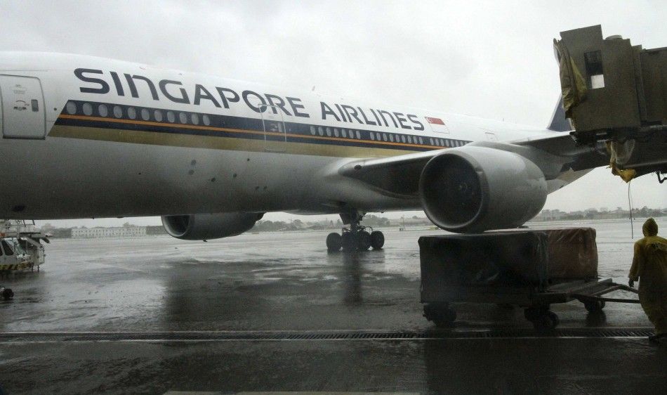 The left wing of a Singapore Airlines passenger plane touches an aerobridge at the Ninoy Aquino International Airport at the onslaught of Typhoon Rammasun, locally named Glenda in Paranaque, Metro Manila July 16, 2014. The typhoon killed at least 10 peo