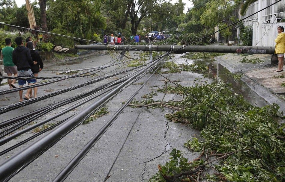 Electric cables lie on a road after its pole fell at the onslaught of Typhoon Rammasun, locally named Glenda at a subdivision in Paranaque, Metro Manila, July 16, 2014. The typhoon killed at least 10 people as it churned across the Philippines and shut 