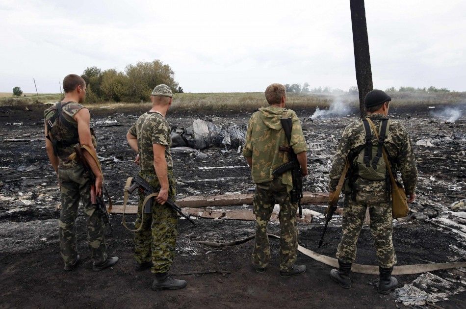 Armed pro-Russian separatists stand at the site of a Malaysia Airlines Boeing 777 plane crash