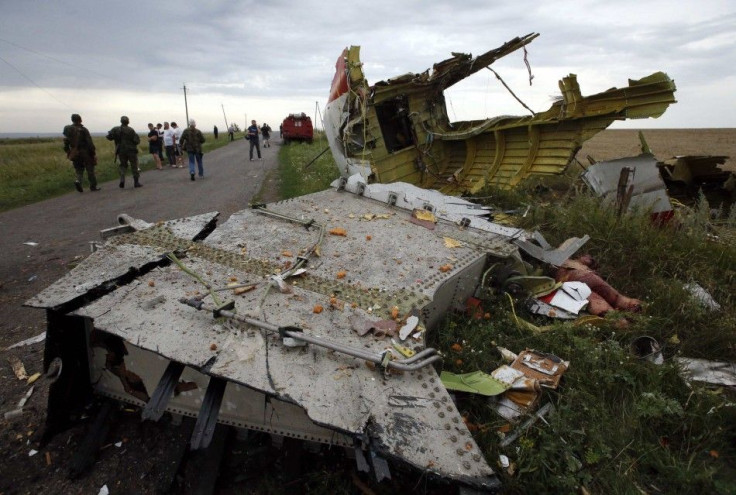 People stand near part of the wreckage of a Malaysia Airlines Boeing 777 