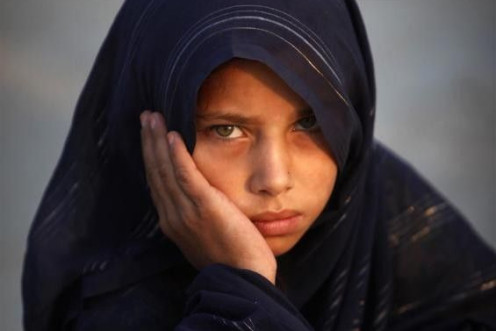 Nida, an internally displaced girl, sits while waiting for handouts at a distribution point for internally displaced persons (IDPs) in Dera Ismail Khan, located in Pakistan&#039;s restive North West Frontier Province, October 30, 2009.