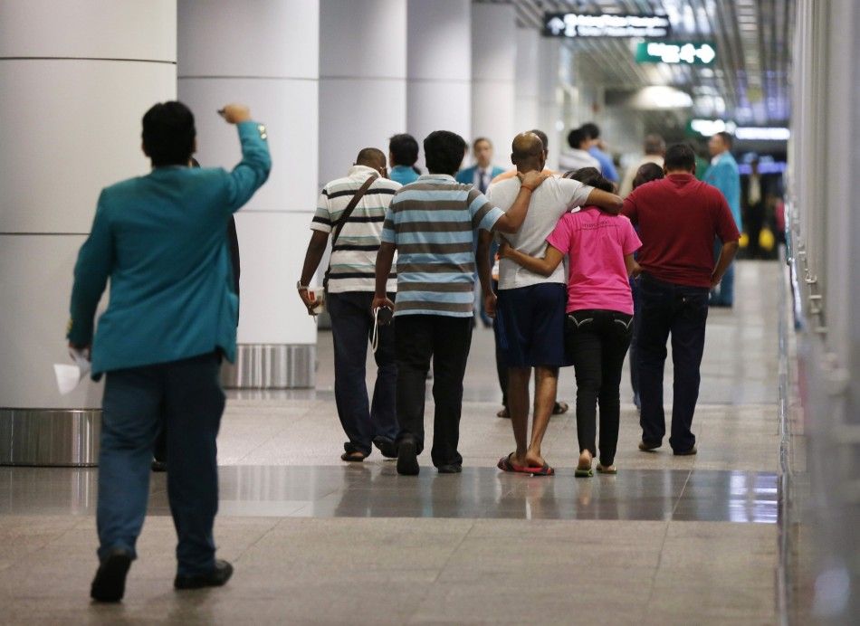 People hug as they leave an area designated for family members of Malaysia Airlines flight MH17 passengers, while waiting for more information about the crashed plane, at Kuala Lumpur International Airport in Sepang July 18, 2014. The Malaysia Airlines Bo