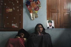 Naseema Dar (R), a 40-year-old &quot;half-widow&quot;, sits next to her 14-year-old daughter Shabnum Mehraj and a photo of her husband Mehraj-ud-Din Dar in their house in Srinagar March 4, 2011. Naseema, a mother of two, is one of Kashmir&#039;s hundreds 