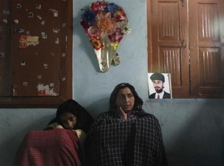 Naseema Dar (R), a 40-year-old &quot;half-widow&quot;, sits next to her 14-year-old daughter Shabnum Mehraj and a photo of her husband Mehraj-ud-Din Dar in their house in Srinagar March 4, 2011. Naseema, a mother of two, is one of Kashmir&#039;s hundreds 