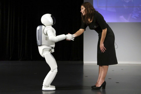 Honda's latest version of the Asimo humanoid robot shakes hands during a presentation