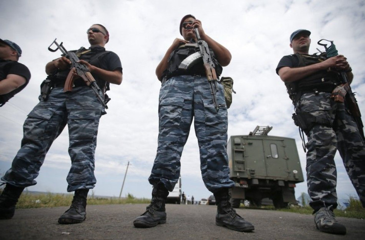 Armed pro-Russian separatists stand guard at a crash site of Malaysia Airlines Flight MH17, near the village of Hrabove