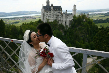 A Chinese bridal couple kiss as they pose in front of the Neuschwanstein castle after their symbolic wedding in Fuessen, in this May 31, 2012 file picture.