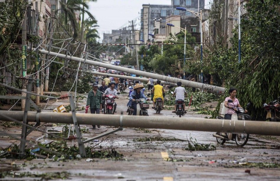 Residents travel on a street blocked by fallen electricity poles after Typhoon Rammasun hit Leizhou, Guangdong province July 19, 2014. A super typhoon has killed at least fourteen people in China since making landfall on Friday afternoon, state media said