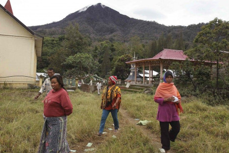 Villagers affected by the Mount Sinabung eruption earlier this year head to a polling station in Medan, Sumatra July 9, 2014. Jakarta Governor Joko &quot;Jokowi&quot; Widodo looked to be heading for a narrow victory in Indonesia&#039;s presidential electi