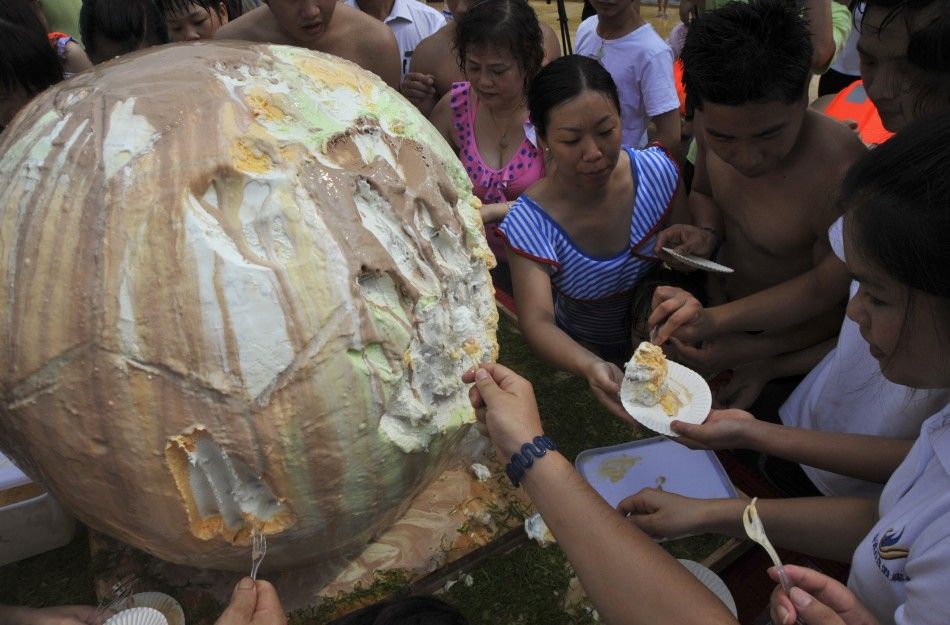Visitors share a giant ice cream in the shape of a soccer ball at a swimming pool resort as a celebration of the 2014 Brazil World Cup, in Qingyuan, Guangdong province June 29, 2014. The ice cream, with a diameter of 1 metre 3.3 feet, weighed over 100 k
