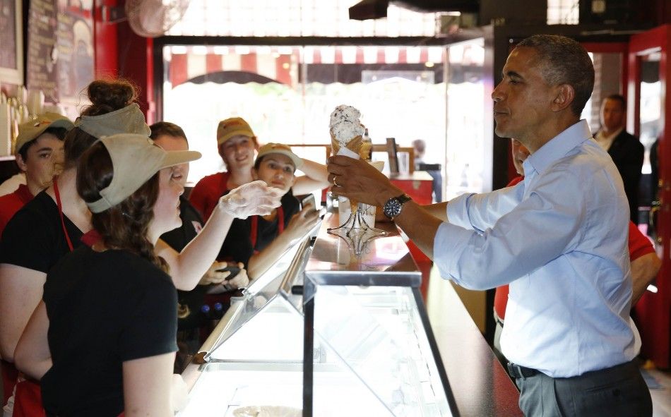 U.S. President Barack Obama buys an ice cream in the Grand Ole Creamery in St. Paul, Minnesota, June 26, 2014. 