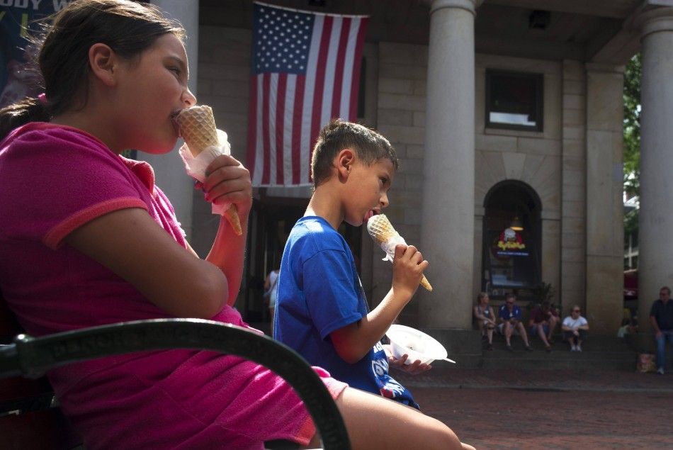 Two children eat ice cream cones at Quincy Marketplace on a summers day in Boston, Massachusetts July 17, 2014. 