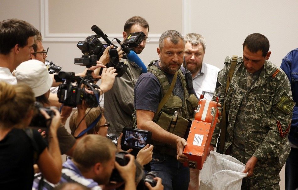 A pro-Russian separatist shows members of the media a black box belonging to Malaysia Airlines flight MH17, before its handover to Malaysian representatives, in Donetsk July 22, 2014. The remains of some of the 298 victims of the Malaysia Airlines plane d