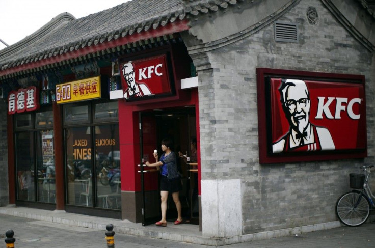 A woman holding an ice cream walks out of a KFC restaurant in Beijing