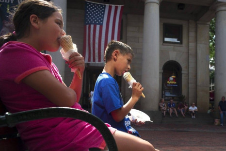 Two children eat ice cream cones at Quincy Marketplace on a summer&#039;s day in Boston, Massachusetts