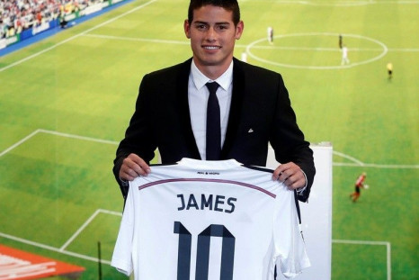 Colombia's soccer player James Rodriguez holds up his new Real Madrid jersey during a presentation at the Santiago Bernabeu stadium in Madrid