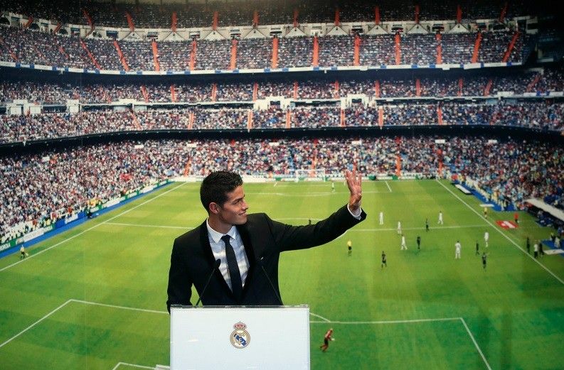 Colombias soccer player James Rodriguez waves to fans during his presentation at the Santiago Bernabeu stadium in Madrid