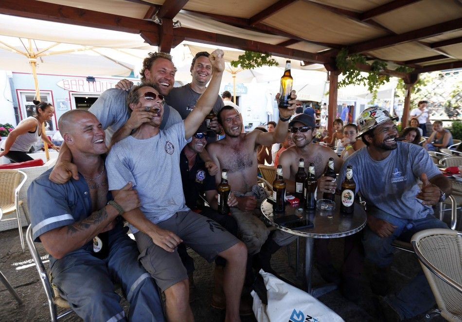 REFILE - CORRECTING GRAMMAR Dutch salvage workers celebrates after the refloat operation maneuvers that allowed cruise liner Costa Concordia to leave Giglio Island July 23, 2014. Maneuvers began early on Wednesday to remove the rusty hulk of the Costa Con