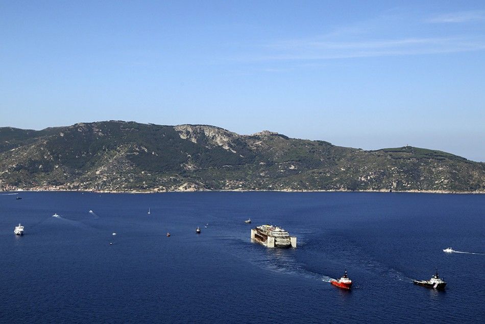The Costa Concordia cruise liner leaves Giglio island after the refloat operation in this July 23, 2014 handout aerial photo provided by Italian Civil Protection .The rusty hulk of the Costa Concordia cruise liner began its journey to the scrapyard on Wed