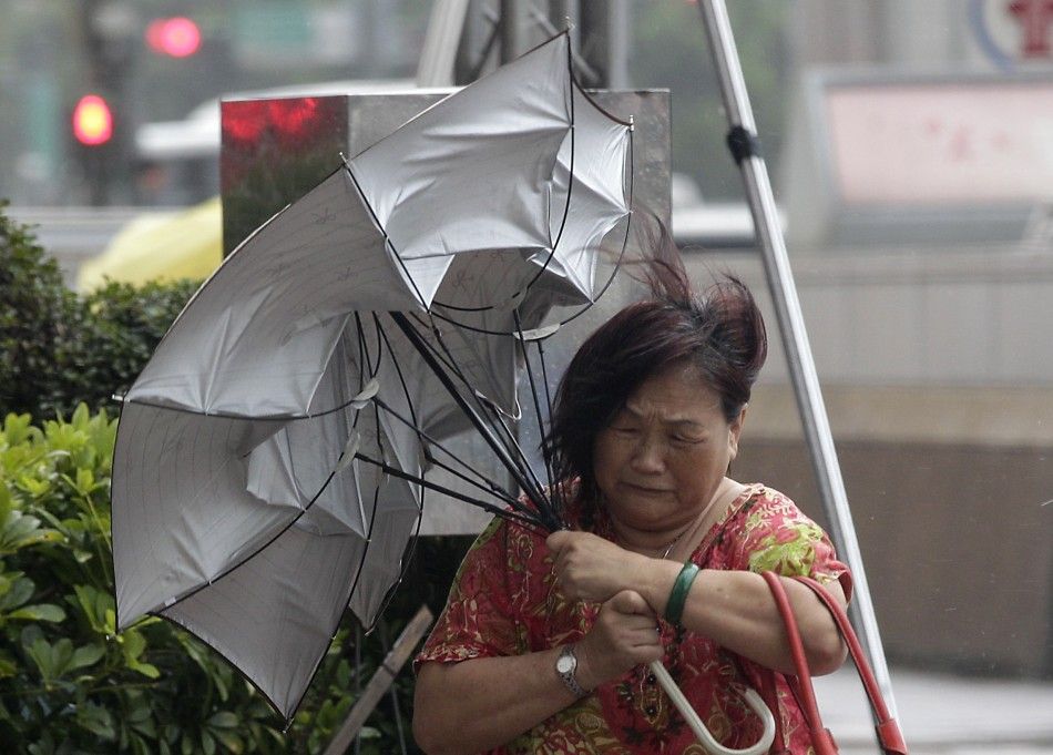 A woman holds her umbrella while walking against strong winds as Typhoon Matmo hits Taiwan, in Taipei July 23, 2014. Typhoon Matmo slammed into Taiwan on Wednesday with heavy rains and strong winds, shutting financial markets and schools, with at least on