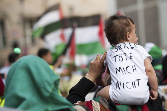 A woman carries a baby with shirt that reads, &quot;Israel don't kill me&quot;, during a demonstration supporting Palestine, in Berlin