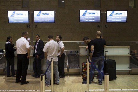 Passengers and airline staff stand near a check-in desk of an airline that cancelled its flight out of Tel Aviv at Ben Gurion International airport July 22, 2014. The Federal Aviation Administration (FAA) banned U.S. carriers from flying to or from Ben Gu