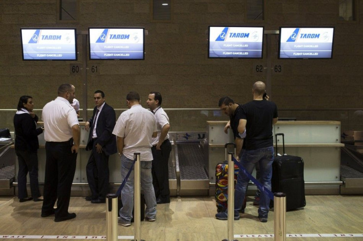 Passengers and airline staff stand near a check-in desk of an airline that cancelled its flight out of Tel Aviv at Ben Gurion International airport July 22, 2014. The Federal Aviation Administration (FAA) banned U.S. carriers from flying to or from Ben Gu