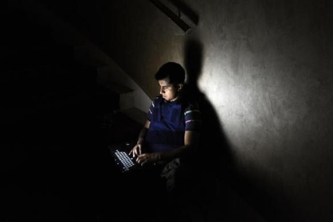 A member of the media works on a staircase at the Rixos hotel during a power cut in Tripoli, Libya August 22, 2011.