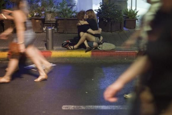 A couple kiss on a side walk of a main street in Tel Aviv during the &quot;White Night&quot; festival June 30, 2011.