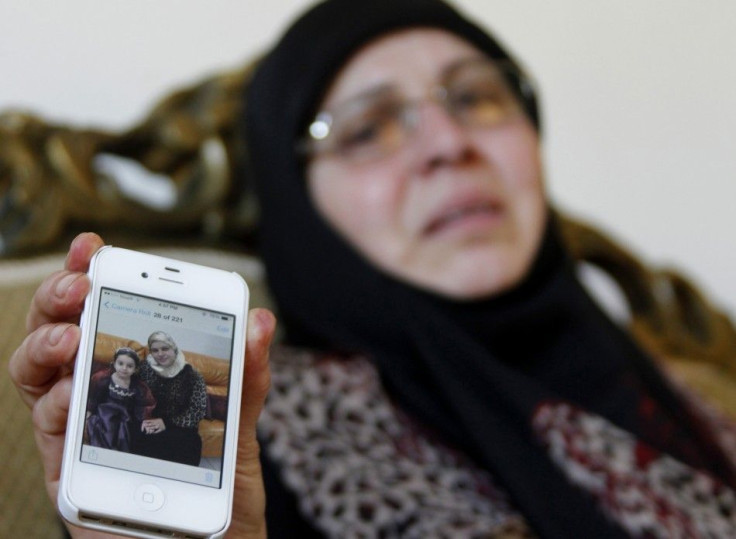 The sister-in-law of Lebanese passenger Randa Daher reacts as she holds her mobile phone displaying a picture of Randa and one of her children at her home in the southern Lebanese village of Srifa July 24, 2014. According to local media, Randa and her chi