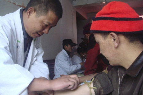 A Chinese researcher collects a blood sample from an ethnic Tibetan man
