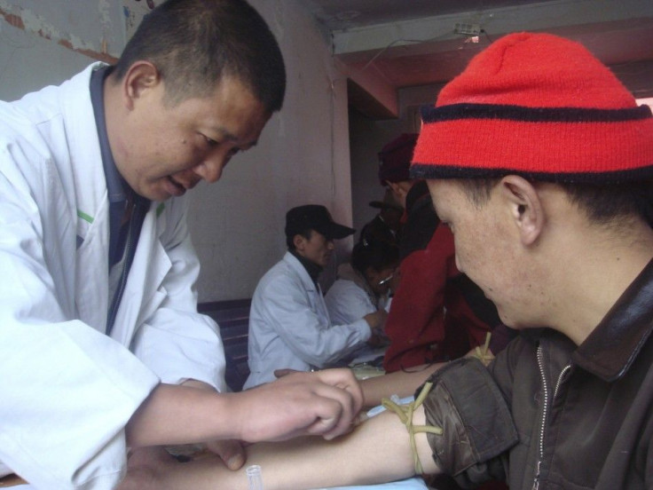 A Chinese researcher collects a blood sample from an ethnic Tibetan man