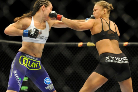 Jul 5, 2014; Las Vegas, NV, USA; Ronda Rousey (red gloves) trades punches with Alexis Davis (blue gloves) during a women&#039;s bantamweight title bout at Mandalay Bay Events Center.