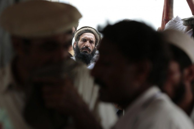 Internally displaced Pakistani men wait in line for rations at a food distribution center in Bannu in Northwest Pakistan July 25, 2014.  REUTERS/Caren Firouz  (PAKISTAN - Tags: CIVIL UNREST SOCIETY)