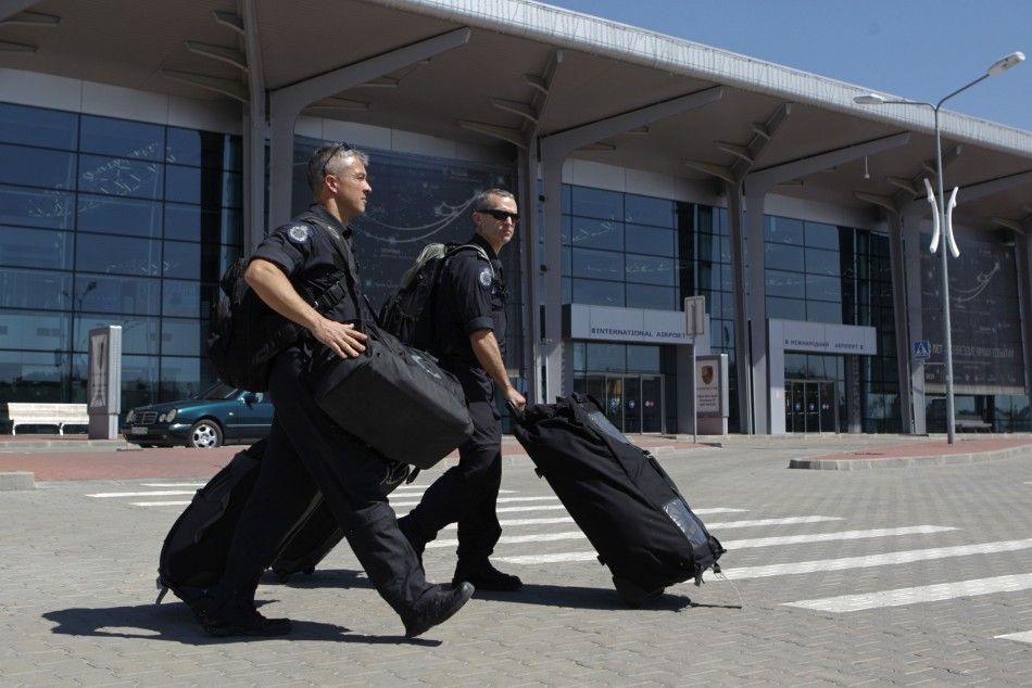 Members of the Australian police mission walk in front of the main terminal after arriving at Kharkiv airport, before proceeding to the crash site of Malaysia Airlines Flight MH17 July 26, 2014. Nearly 300 people, 193 of them Dutch citizens, were killed w
