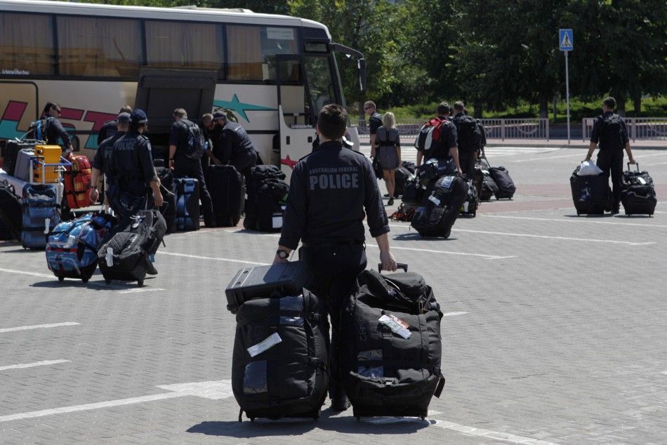 Members of the Australian police mission walk to a bus after arriving at Kharkiv airport, before proceeding to the crash site of Malaysia Airlines Flight MH17 July 26, 2014. Nearly 300 people, 193 of them Dutch citizens, were killed when the Malaysia Airl
