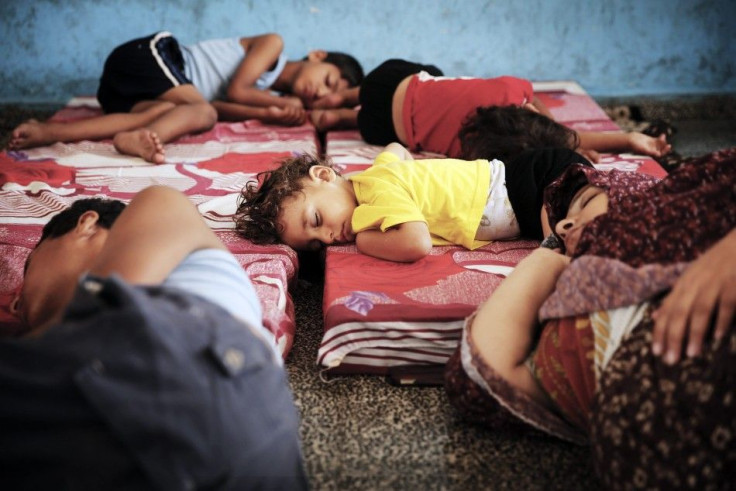 Palestinians sleep at a United Nations school, where people who fled heavy Israeli shelling in the Shejaia neighbourhood sought refuge during fighting, 