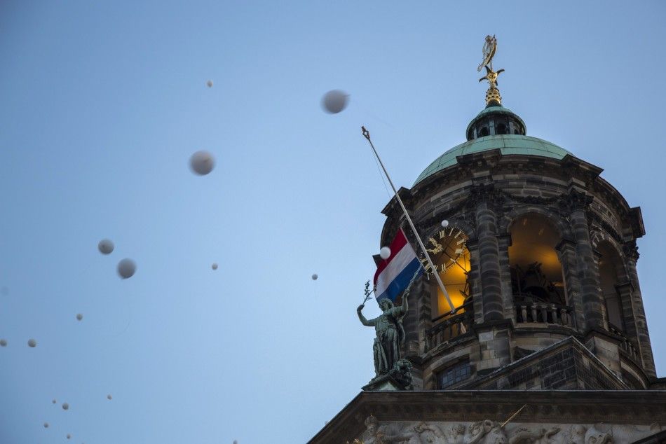People release balloons to pay their respects during a national day of mourning for the victims killed in Malaysia Airlines Flight MH17 plane disaster, in Amsterdam July 23, 2014. The bodies of the first victims from a Malaysian airliner shot down over Uk